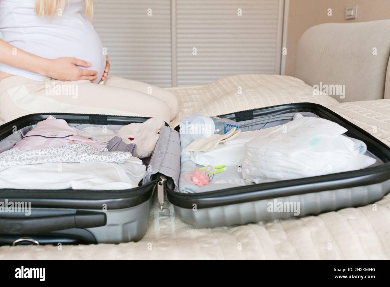 Mujer embarazada joven maleta de embalaje para hospital de maternidad en  casa, closeup. Lista de verificación para el parto. Embarazo durante el  coronavirus covid-19 pandemi Fotografía de stock - Alamy