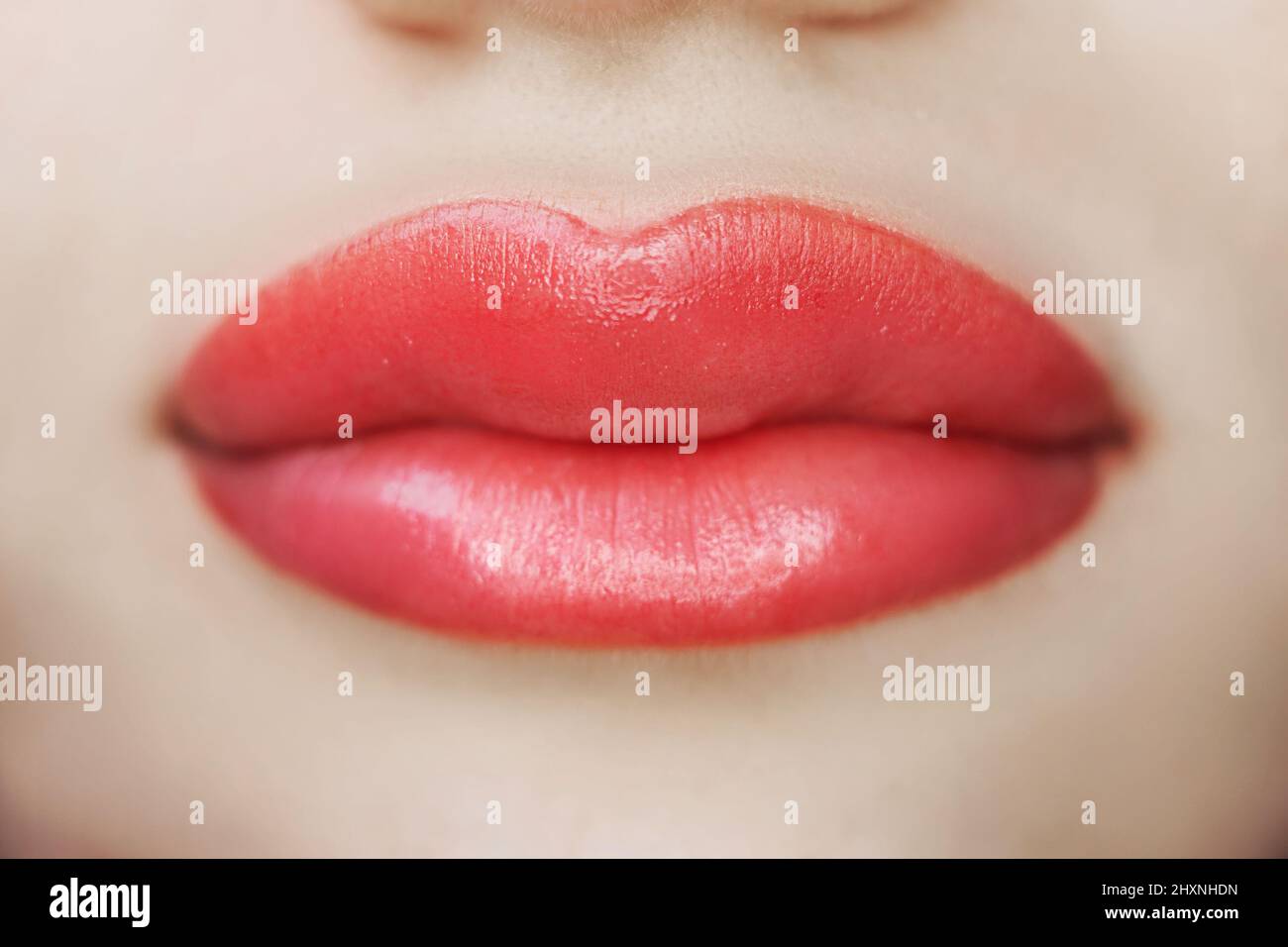 Primeros planos de los labios después del tatuaje con pigmento para colorear, maquillaje permanente de los labios de la mujer en el salón de belleza, belleza y salud Foto de stock