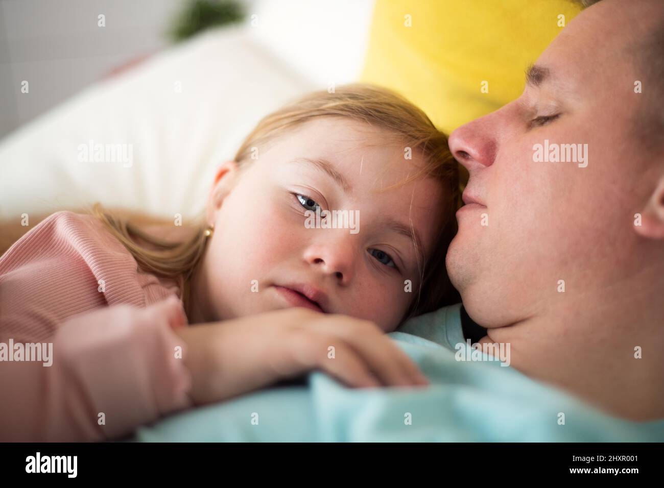 Padre Descansando Con Su Hija Pequeña Con Síndrome De Down En Cama En Casa Fotografía De Stock 9580