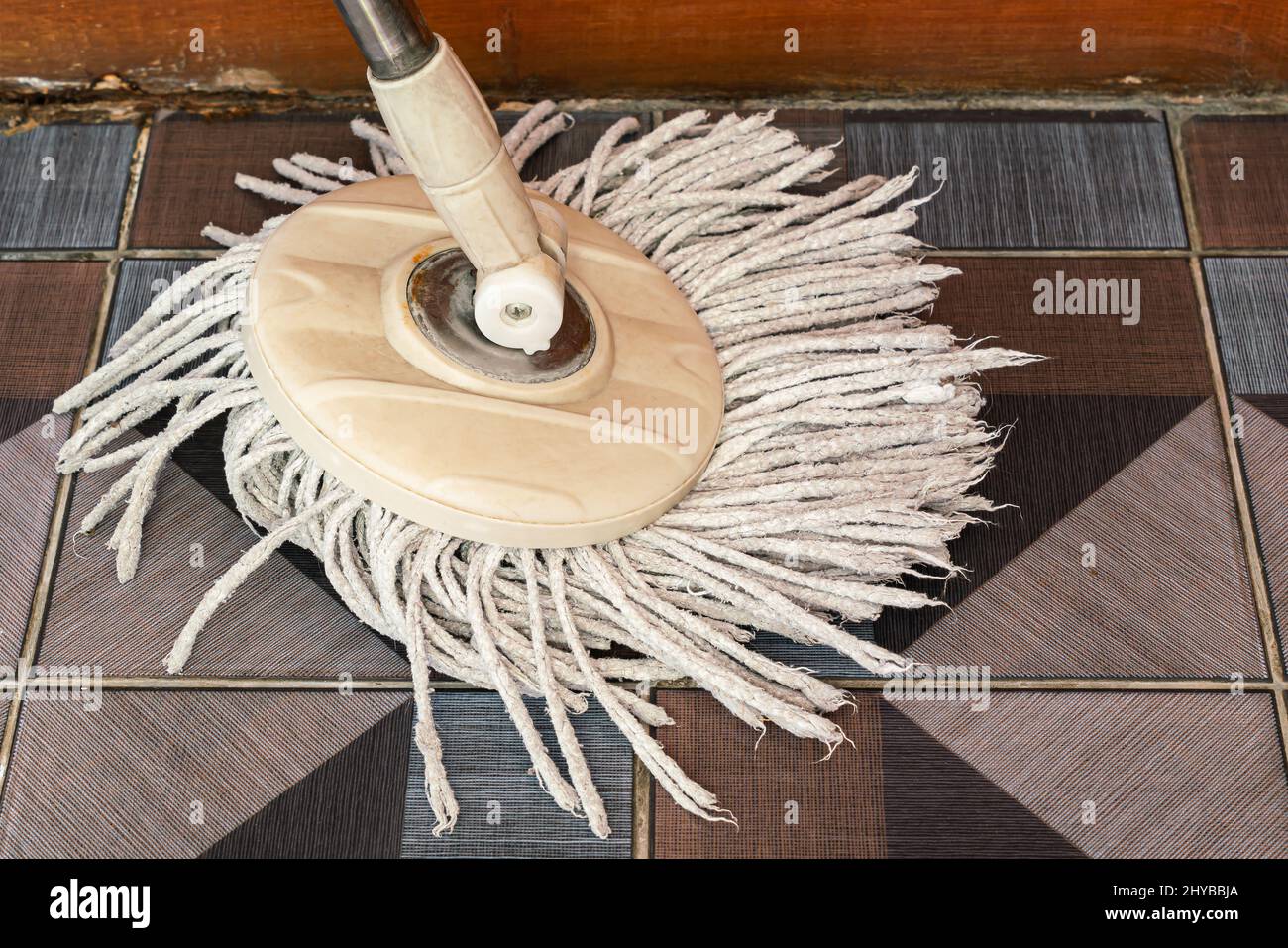 Vista de fregona de limpieza usada con microfibra en suelo de cerámica en una casa. Foto de stock