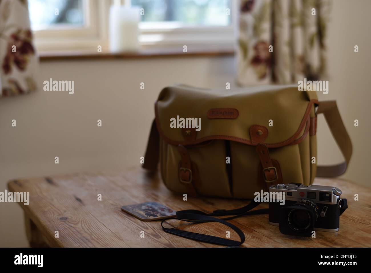 Primer plano de Leica M6 y bolsa para cámara Billingham sobre la mesa de madera Foto de stock