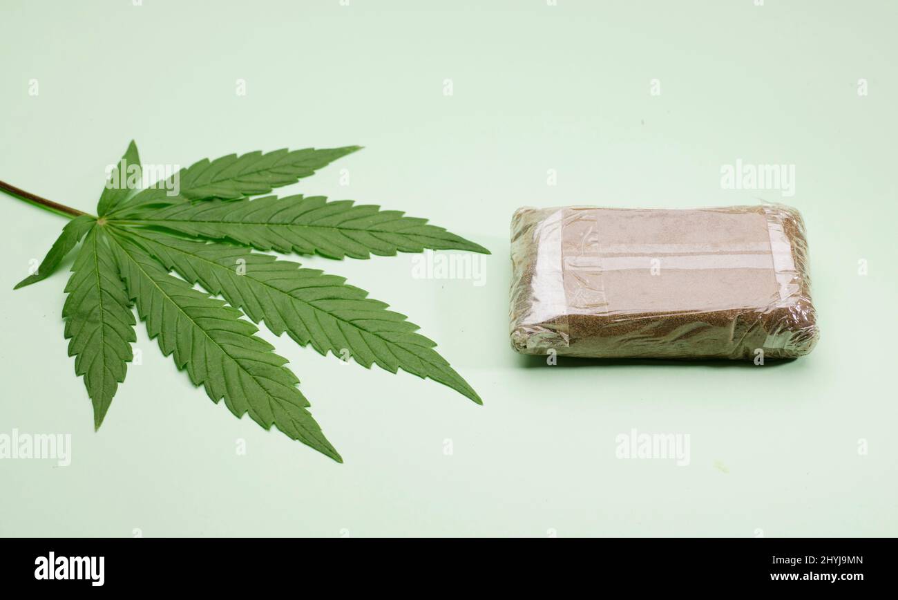 tableta hachís con hoja de marihuana, fondo verde Fotografía de stock -  Alamy