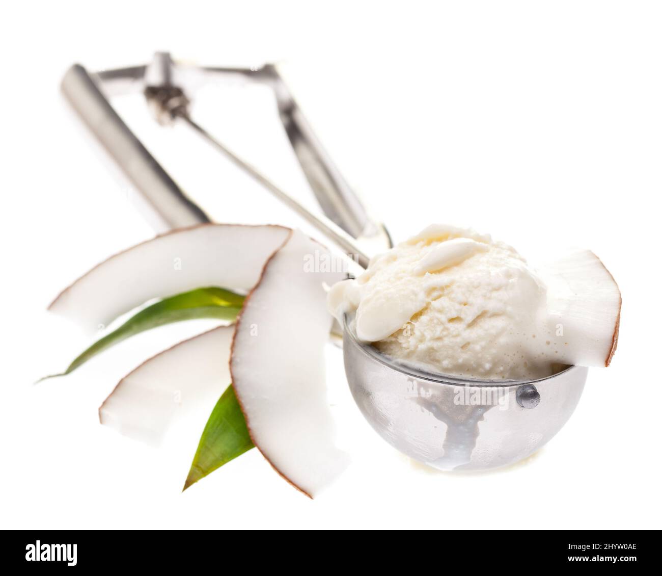 cuchara de helado con helado de coco una rodajas de coco y hojas aisladas sobre fondo blanco Foto de stock