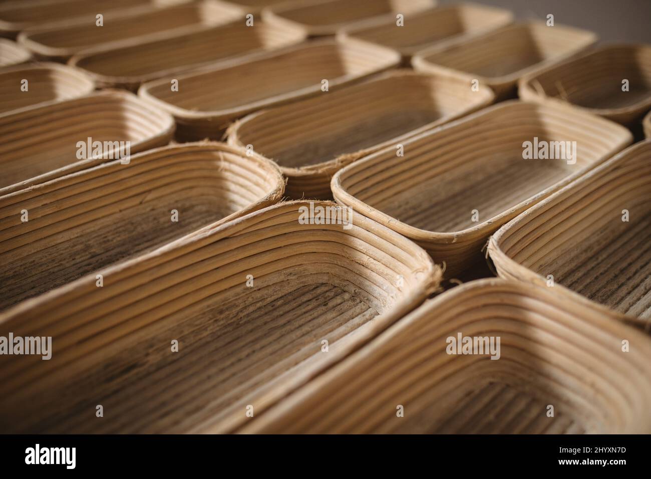 Tiro de marco completo de cestas de pan de mimbre dispuestas lado a lado en la panadería Foto de stock