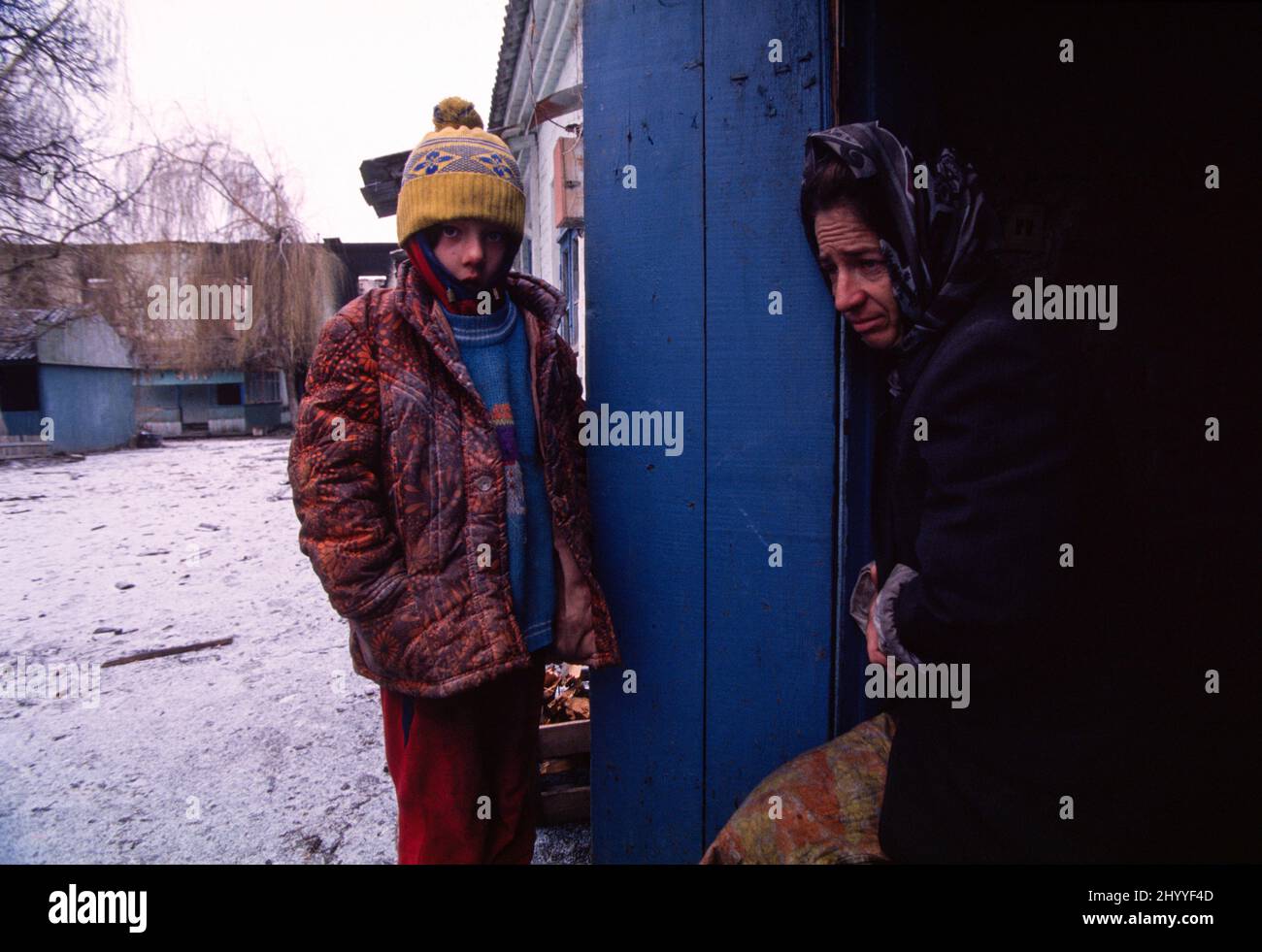 Primera Guerra de Independencia de Chechenia de Rusia (1994-1995). Madre chechena e hija de ocho años a la puerta del sótano de una escuela bombardeada al sur de Grozny, la capital de la República chechena. 28 de diciembre de 1994. Foto de stock