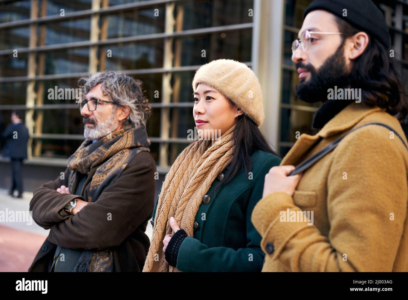 Un grupo multiétnico de tres personas de diferentes edades en un centro de negocios posando para una foto. Foto de stock