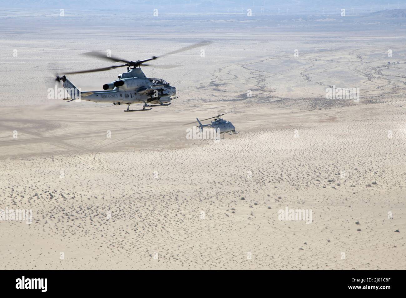 Un víbora AH-1Z (izquierda) con escuadrón de evaluación operacional y de pruebas marinas 1 (VMX-1), y un helicóptero MQ-8C Fire Scout no tripulado asignado al escuadrón de combate marítimo en helicóptero 23 (HSC-23), conducen la coordinación de huelgas y el entrenamiento de reconocimiento cerca de El Centro, California, el 10 de marzo de 2022. El propósito de este ejercicio fue proporcionar familiarización y desarrollo conceptual de la formación de equipos tripulados y no tripulados. (EE.UU Marine Corps foto por Lance Cpl. Jade Venegas) Foto de stock