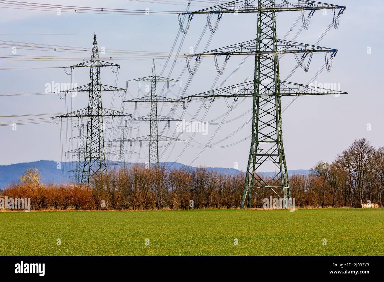 Varias torres de transmisión con líneas eléctricas para transportar electricidad para lograr la Energiewende alemana Foto de stock