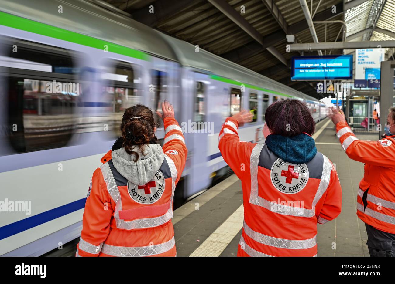 Estación de tren de Frankfurt, Alemania. 16 de marzo de 2022, Brandeburgo,  Frankfurt (Oder): Voluntarios de la Cruz Roja se ponen de pie agitando en  una plataforma en la estación de tren