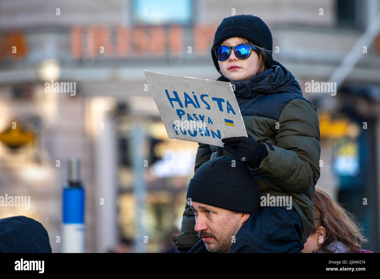 Haista paska Puuttin. Niño con un cartel de cartón en protesta contra la invasión de Ucrania. Helsinki, Finlandia. Foto de stock