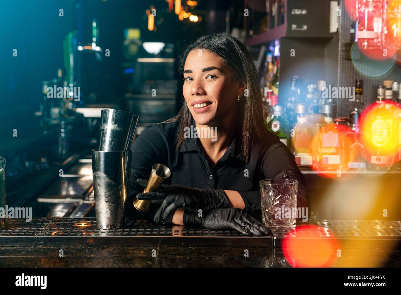 La camarera latina de brunette prepara un cóctel en el bar Foto de stock