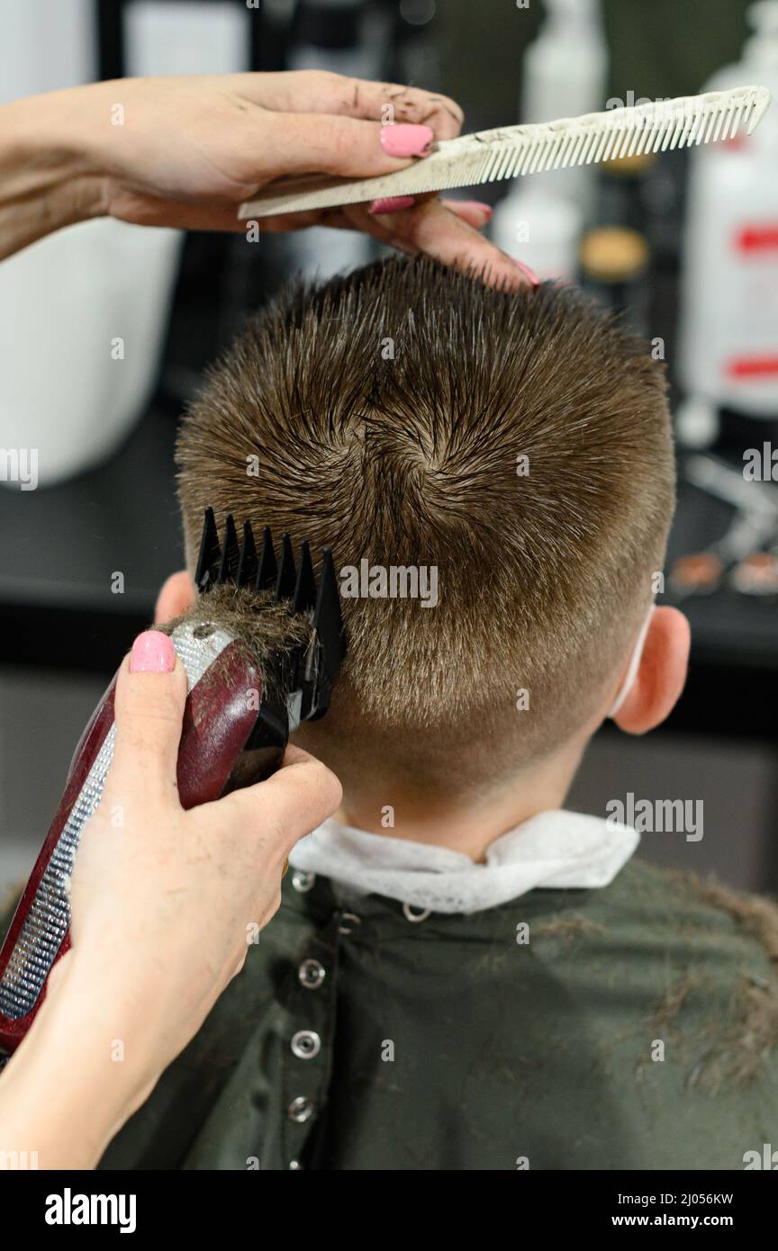 Corte de pelo para niños en la barbería, corte de pelo moderno y elegante  para escolares, trabajo durante la pandemia, corte de pelo para niños con  tijeras Fotografía de stock - Alamy