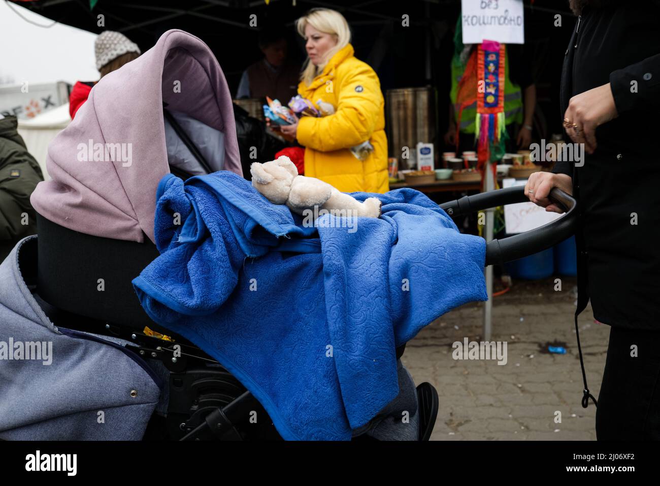 Se ve un porteador de bebés con un juguete de oso con una manta azul al  entrar en el campamento de refugiados en la frontera con Ucrania en Medyka,  Polonia, el 16th