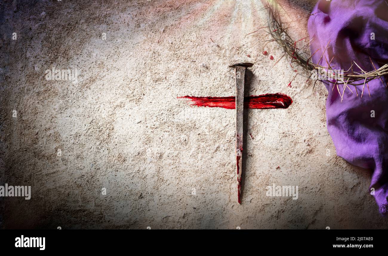 Cruz y Pasión - Calvario y Crucifixión de Jesús - Corona de espinas y espinas sangrientas con manto púrpura en tierra Foto de stock