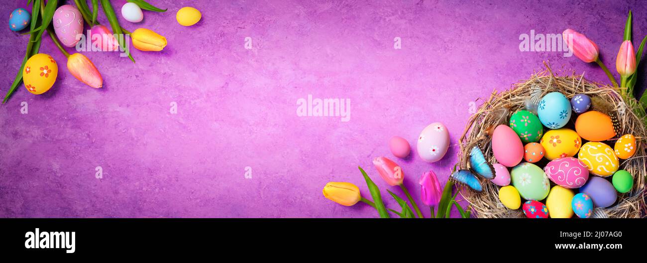 Huevos de Pascua - Tulipanes y decoraciones sobre fondo violeta terciopelo Foto de stock