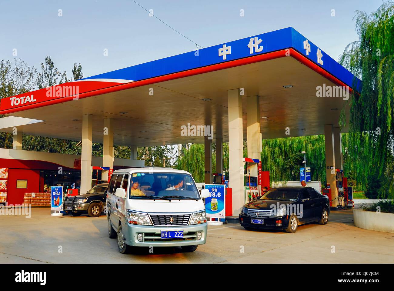 Pekín, China, Coches conduciendo en la gasolinera de servicio 'Total Sinochem', capitalismo chino Foto de stock