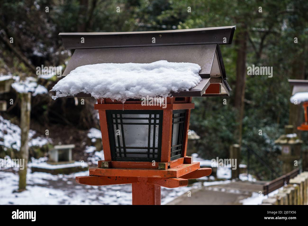 Tradicional linterna de madera japonesa cubierta de nieve en el templo de Kurama-dera en Kioto, Japón Foto de stock
