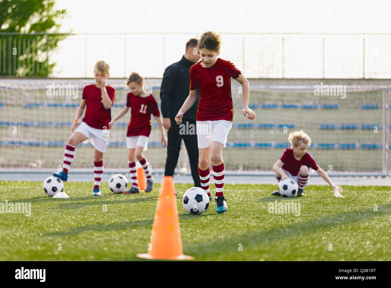Niño Saltando Sobre Conos De Fútbol En Campo De Entrenamiento De Fútbol  Foto de archivo - Imagen de club, muchacho: 178438588