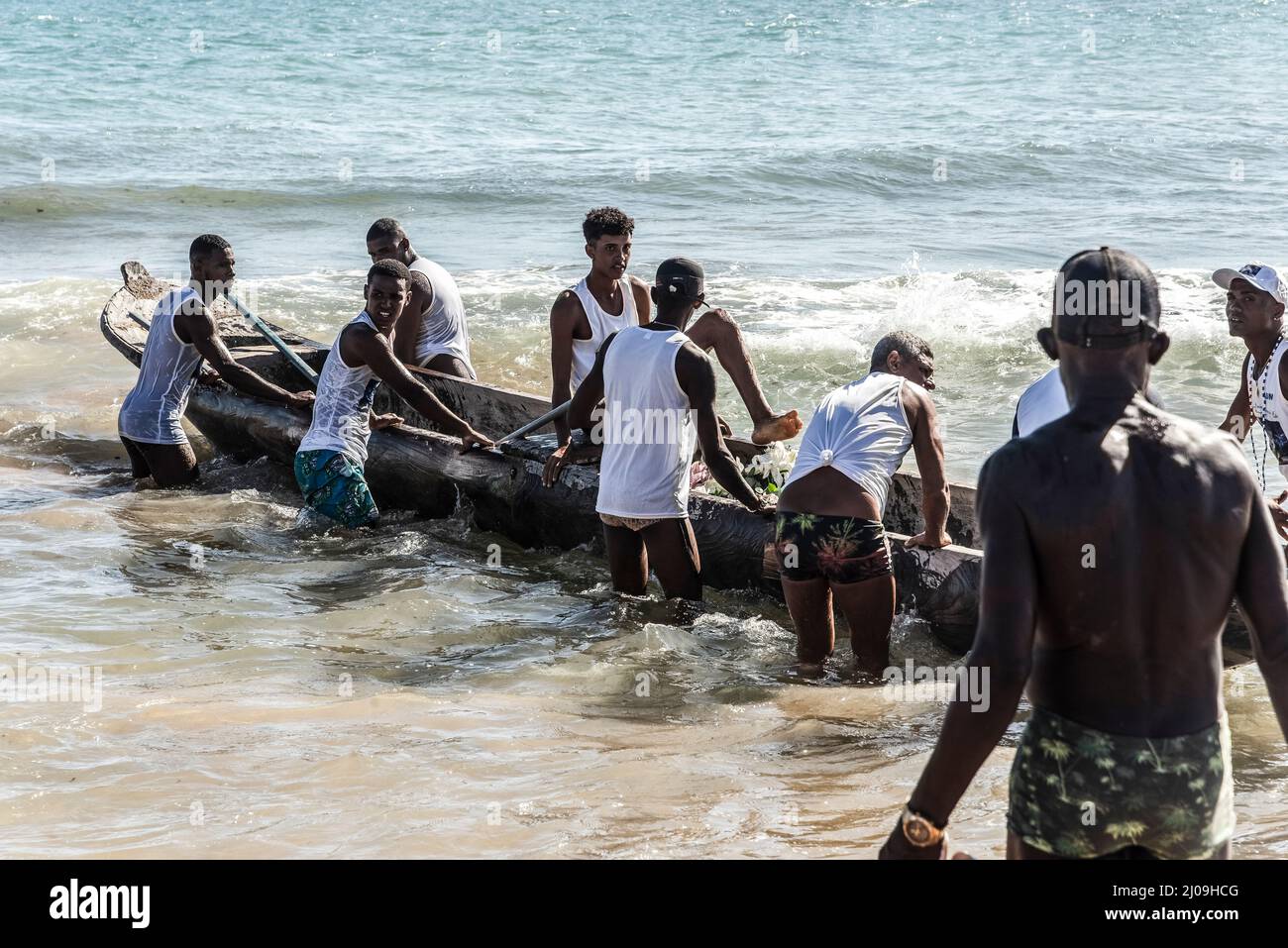 Pescadores poniendo canoa en el mar para la entrega de regalos de Iemanjá  en la playa Boca do Río en Salvador, Bah Fotografía de stock - Alamy