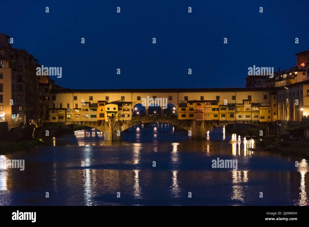 Vista nocturna del Ponte Vecchio, un puente medieval sobre el río Arno, Florencia, Toscana, Italia Foto de stock
