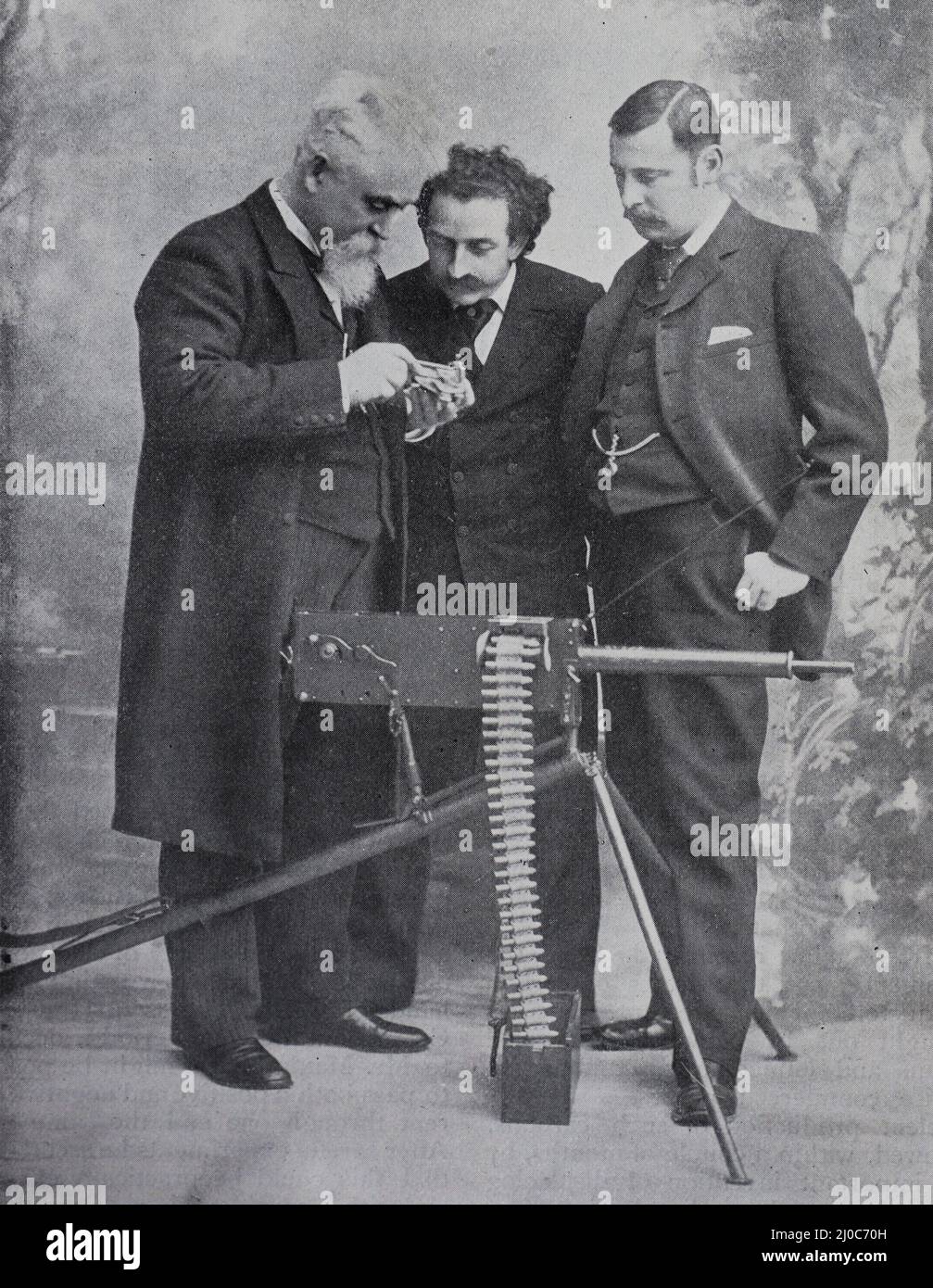 Sir Hiram Stevens Maxim demostrando su última ametralladora a Louis Cassier y J. Bucknall Smith, diseñado para el emperador de Alemania; alrededor de 1895 Foto de stock