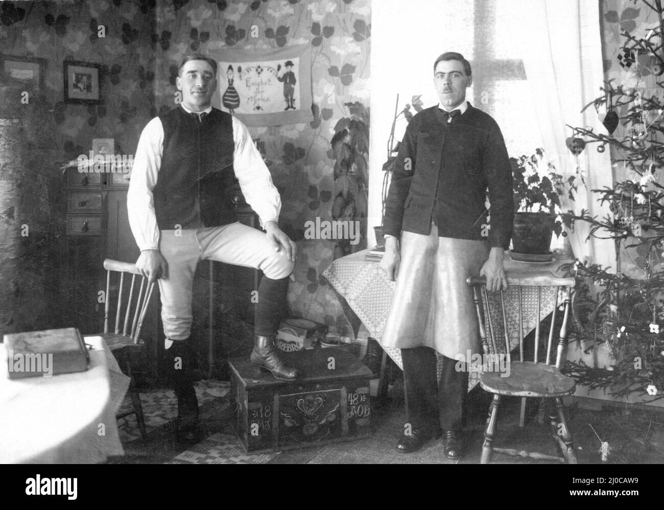 Auténtica fotografía vintage de dos jóvenes de pie en el salón mirando a la cámara, Suecia Foto de stock