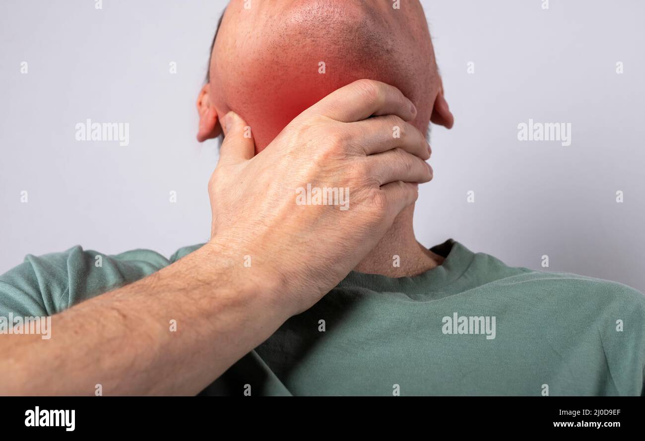 Dolor de garganta. Mano del hombre tocando el cuello doloroso con el punto rojo de cerca. Problemas de salud, concepto de medicina. Fotografías de alta calidad Foto de stock