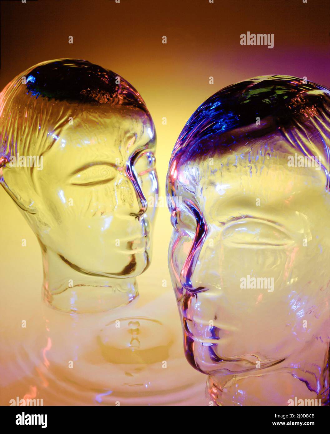 Par de cabezas de vidrio conceptual con caída de agua y ondulaciones Foto de stock