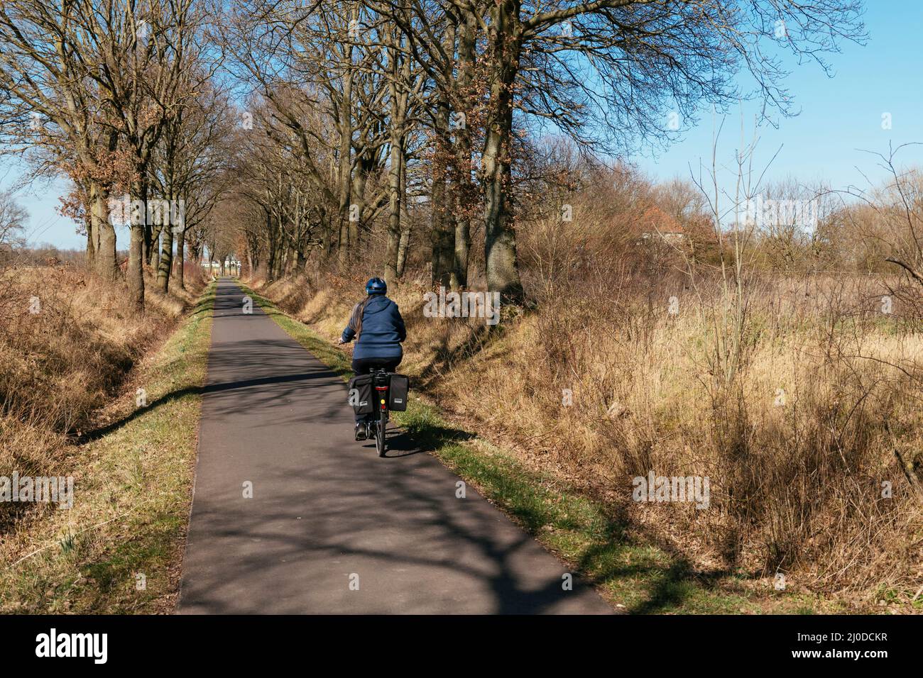 Mujer en bicicleta en la ruta Weser cerca de Petershagen. Foto de stock