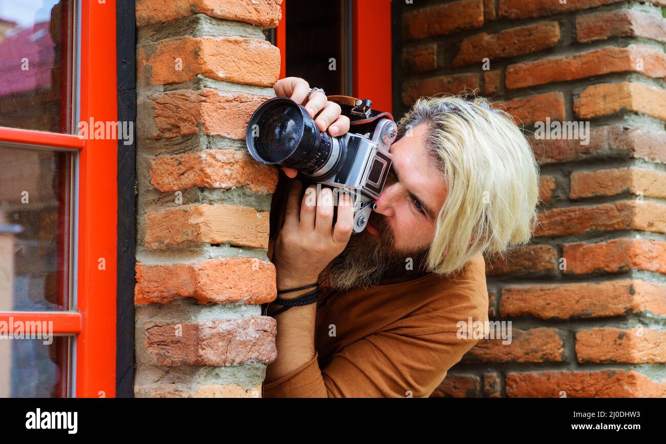 Paparazzi tomando fotos con fotocamera. Hombre espía. Detective privado. Espionaje. Investigación. Foto de stock