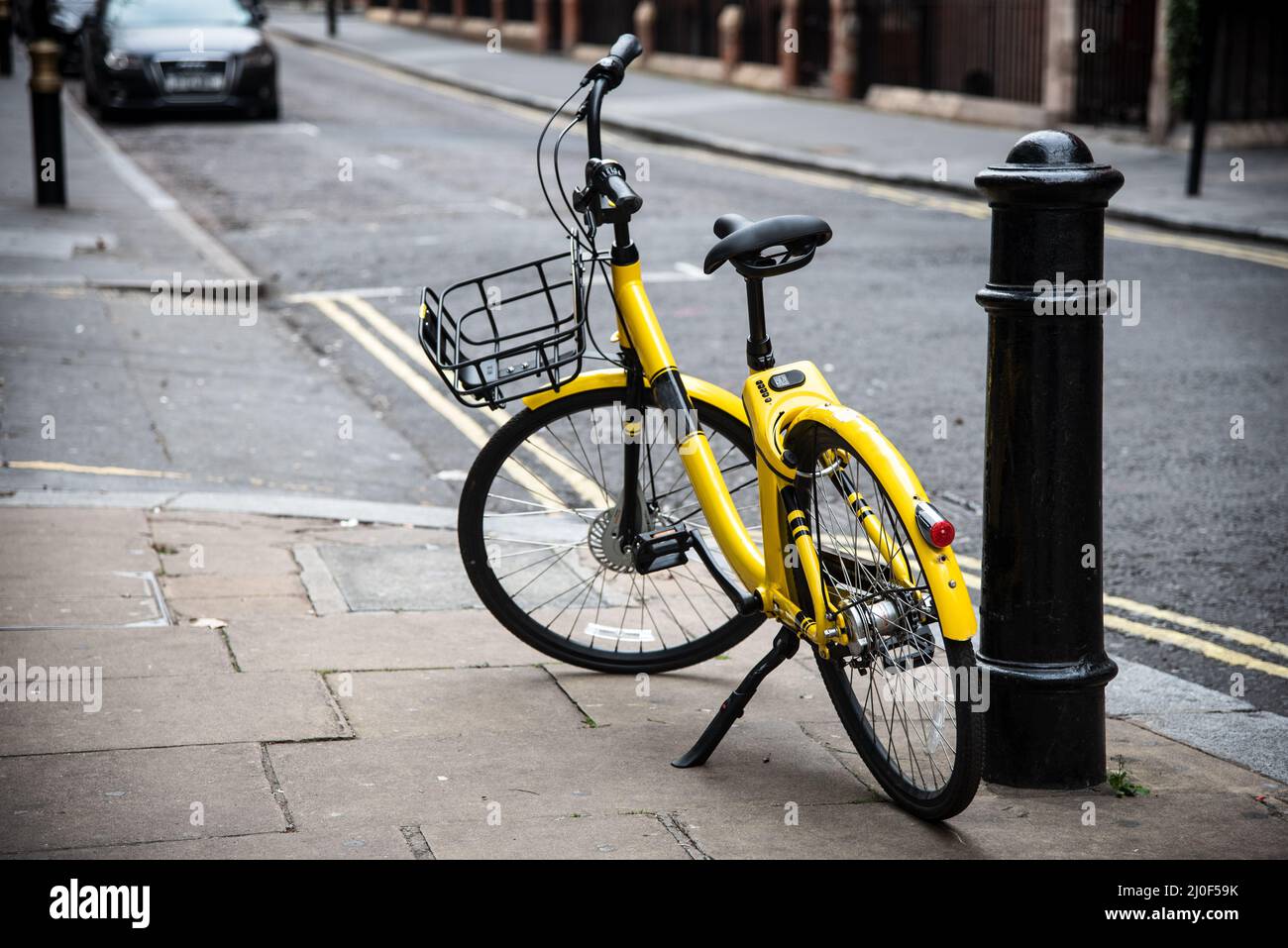 Bicicleta amarilla aparcada en la carretera. Foto de stock