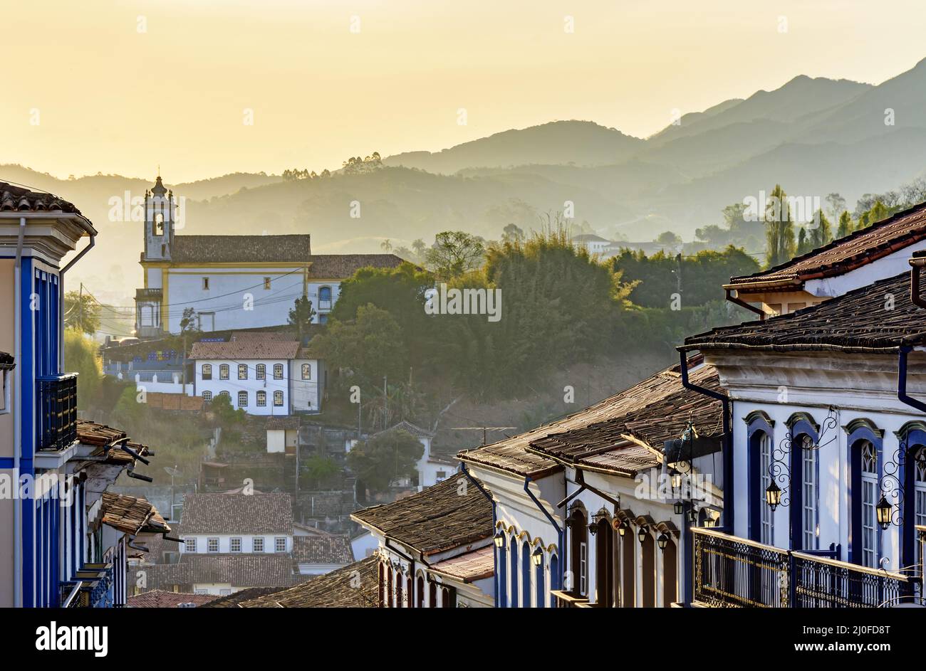 Fachadas de casas e iglesias de arquitectura colonial en una calle antigua de la ciudad de Ouro Preto Foto de stock