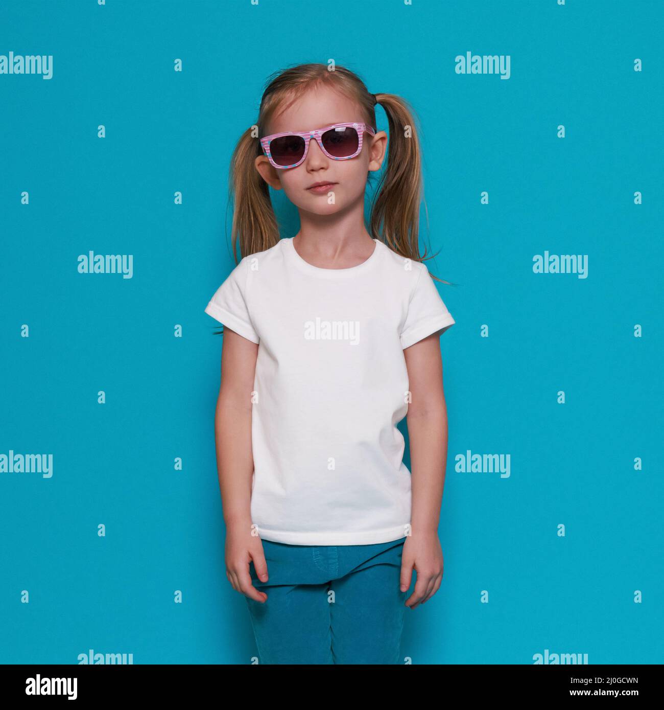 Mockup camiseta blanca, niña europea en ropa de verano, gafas de sol sobre  fondo azul Fotografía de stock - Alamy