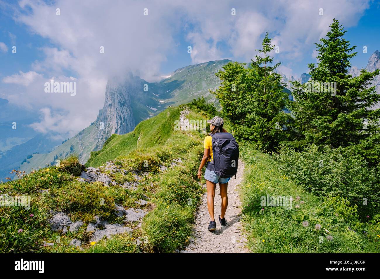 joven mujer de senderismo de pie en la roca superior, mujer mochila mirando  el hermoso valle