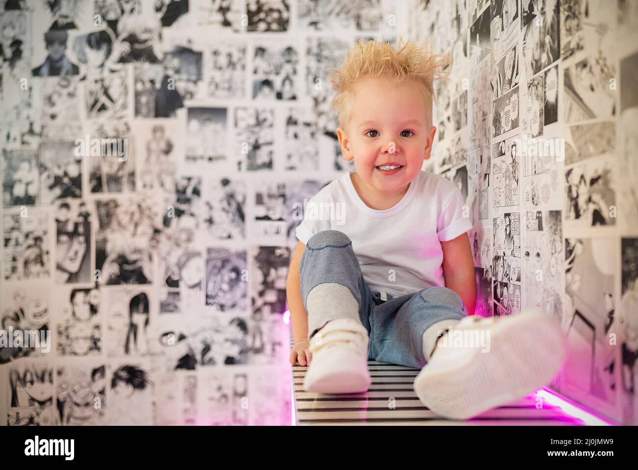 retrato niño rubio con estilo en habitación de neón Foto de stock