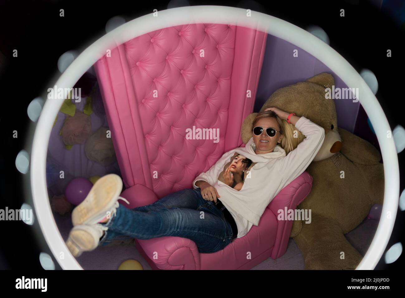 Retrato niña elegante sentarse en una silla rosa. Foto de stock