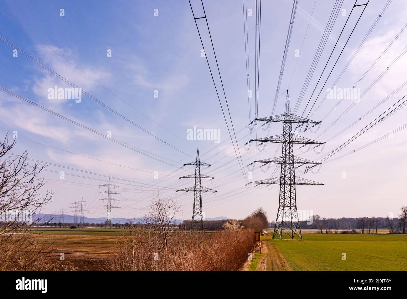 Imágenes de drone de líneas eléctricas y muchos polos de potencia en el entorno rural de Alemania Foto de stock
