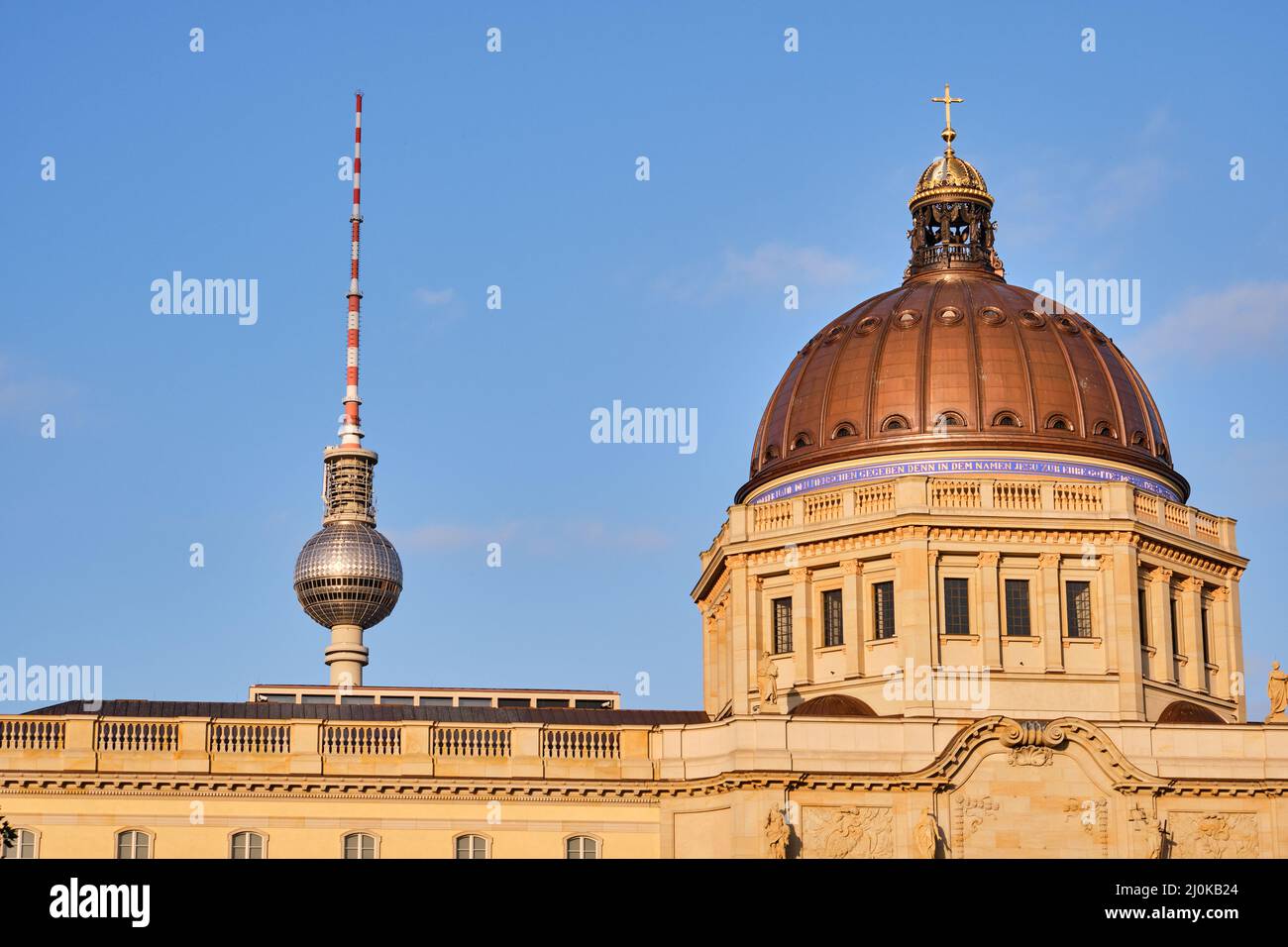 La cúpula del reconstruido Palacio de la Ciudad de Berlín y la famosa Torre de TV justo antes de la puesta de sol Foto de stock