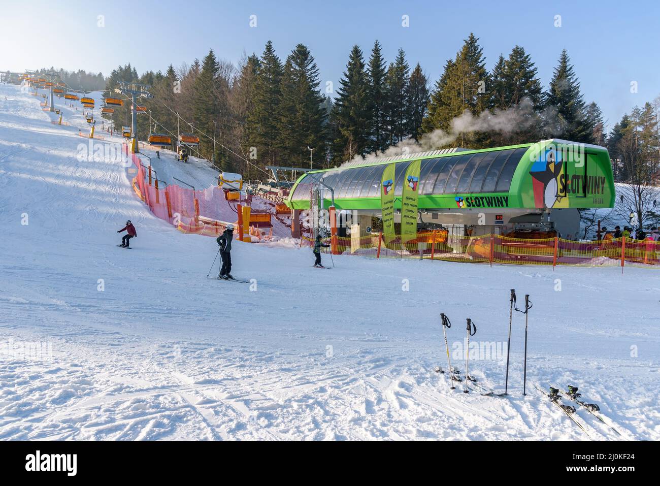 Krynica Zdroj, Polonia - 27 de enero de 2020: Esquiadores en la estación inferior de telesilla moderna en la estación de esquí Slotwiny Arena Foto de stock