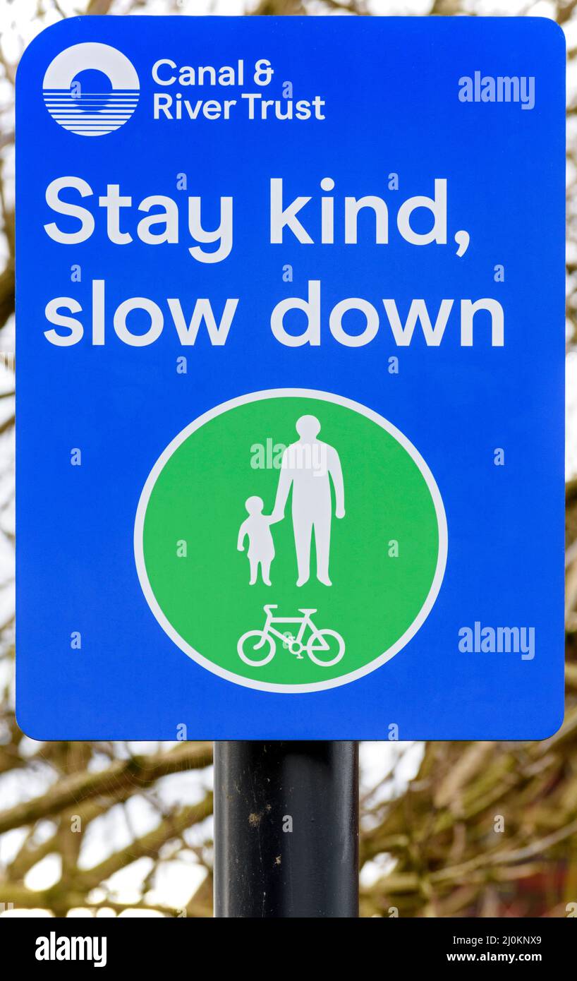 Señal pidiendo ciclistas a Vaya más despacio. En la vía de sirga del Canal Ashton, Droylsden, Tameside, Manchester, Inglaterra, REINO UNIDO Foto de stock