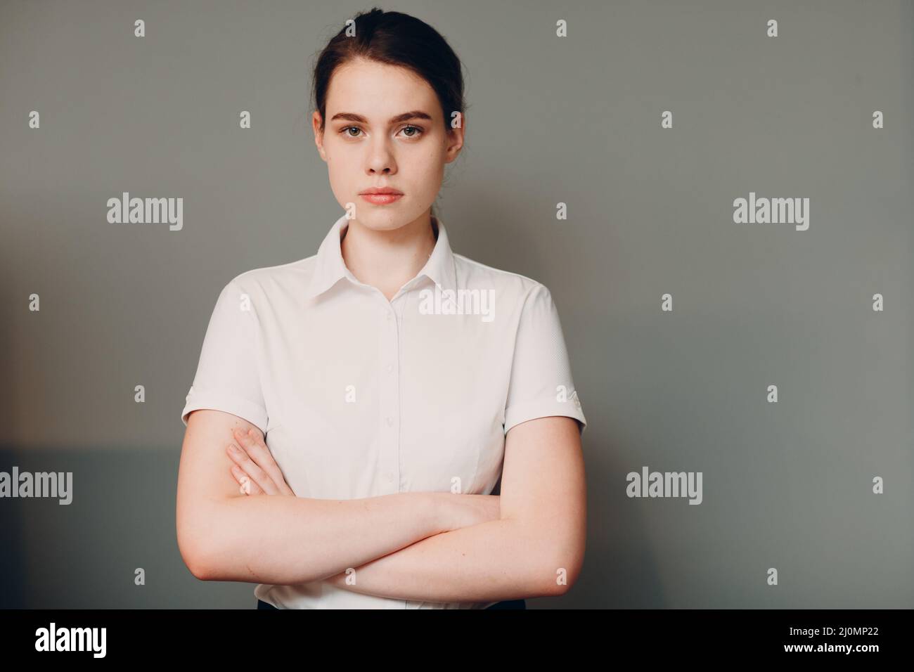 Mujer joven de negocios de 20 25 años retrato en camisa blanca de pie en la oficina Foto de stock