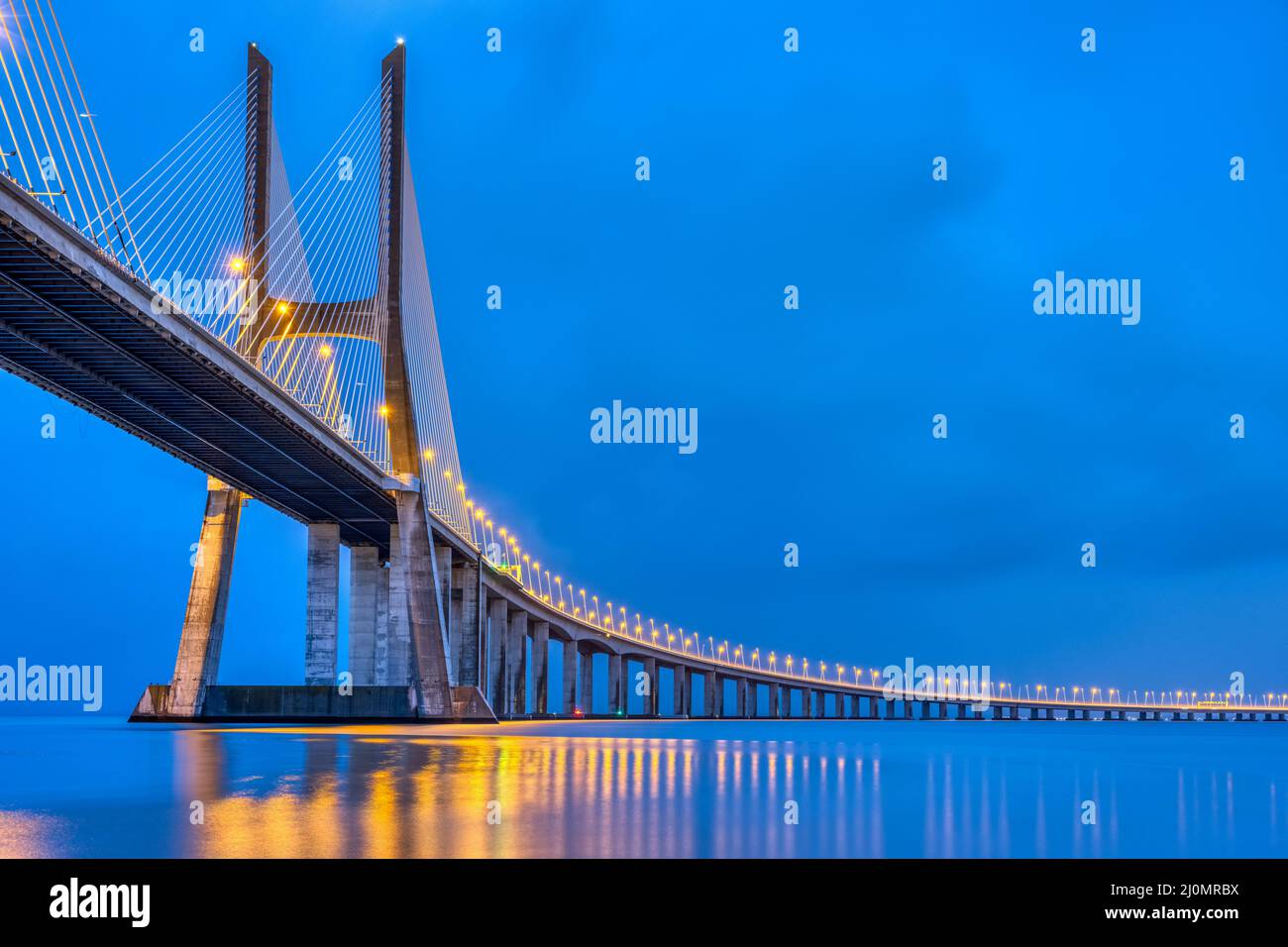 El puente Vasco da Gama cruzando el río Tajo en Lisboa, Portugal, al atardecer Foto de stock