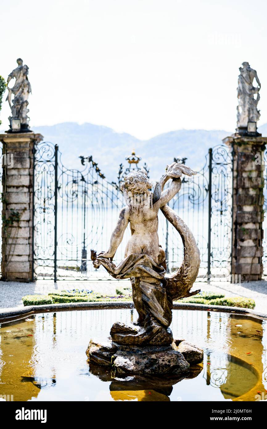 Estatua de una sirena en la fuente en el jardín frente a la puerta. Villa Monastero, Italia Foto de stock