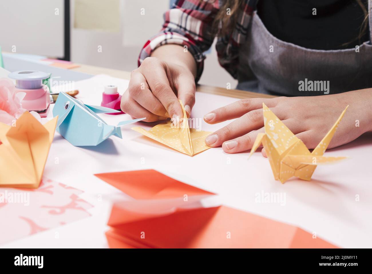 Primer plano mujer mano hacer arte creativo artesanía utilizando papel origami Foto de stock