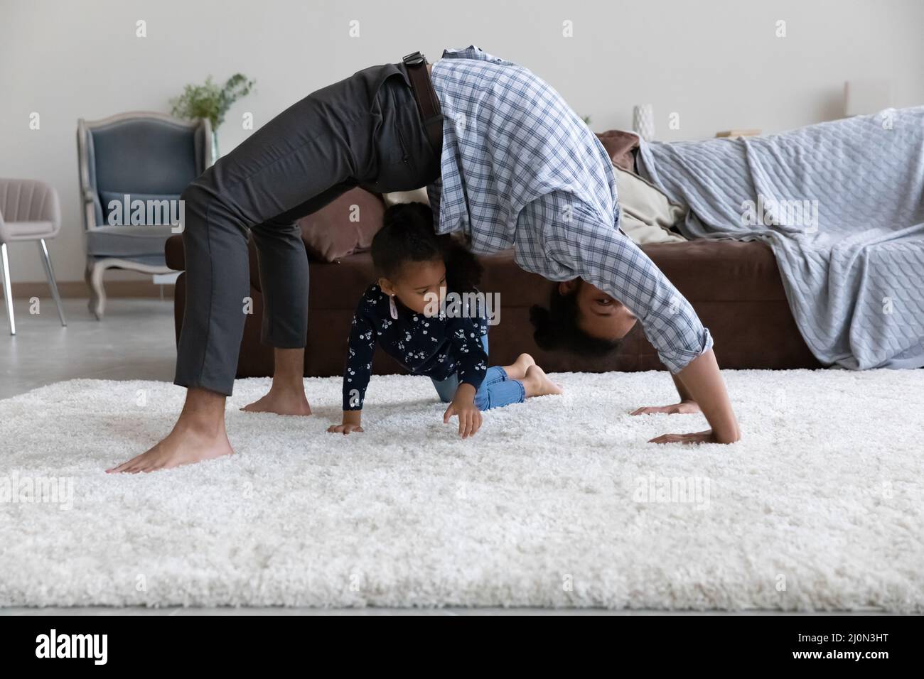 Soporte de puente de sujeción Active yogi dad sobre alfombra blanca y suave Foto de stock