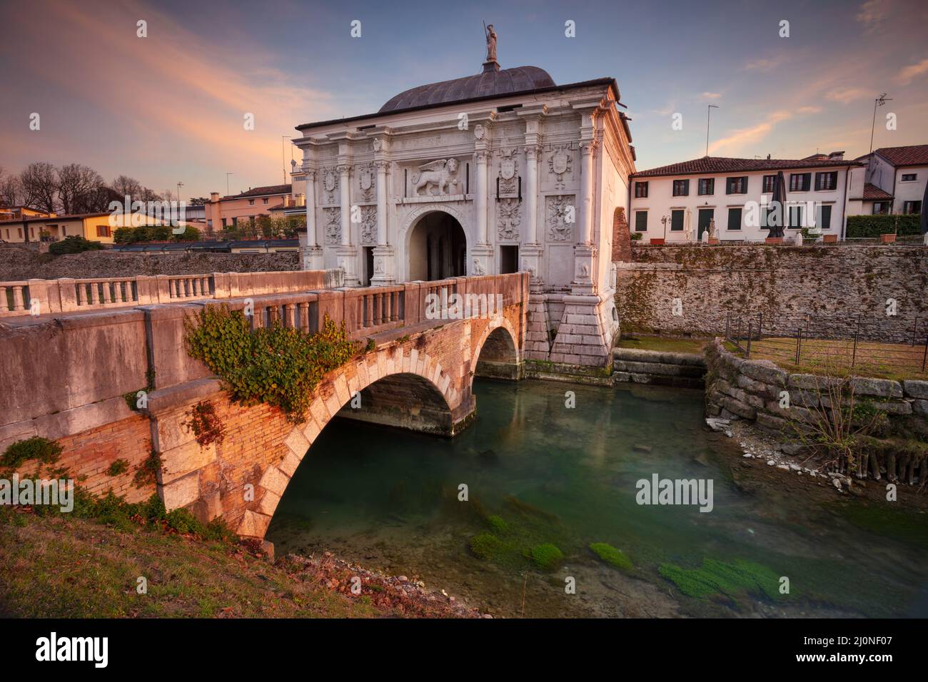 Treviso, Italia. Imagen del paisaje urbano de Treviso, Italia con puerta a la ciudad vieja al atardecer. Foto de stock