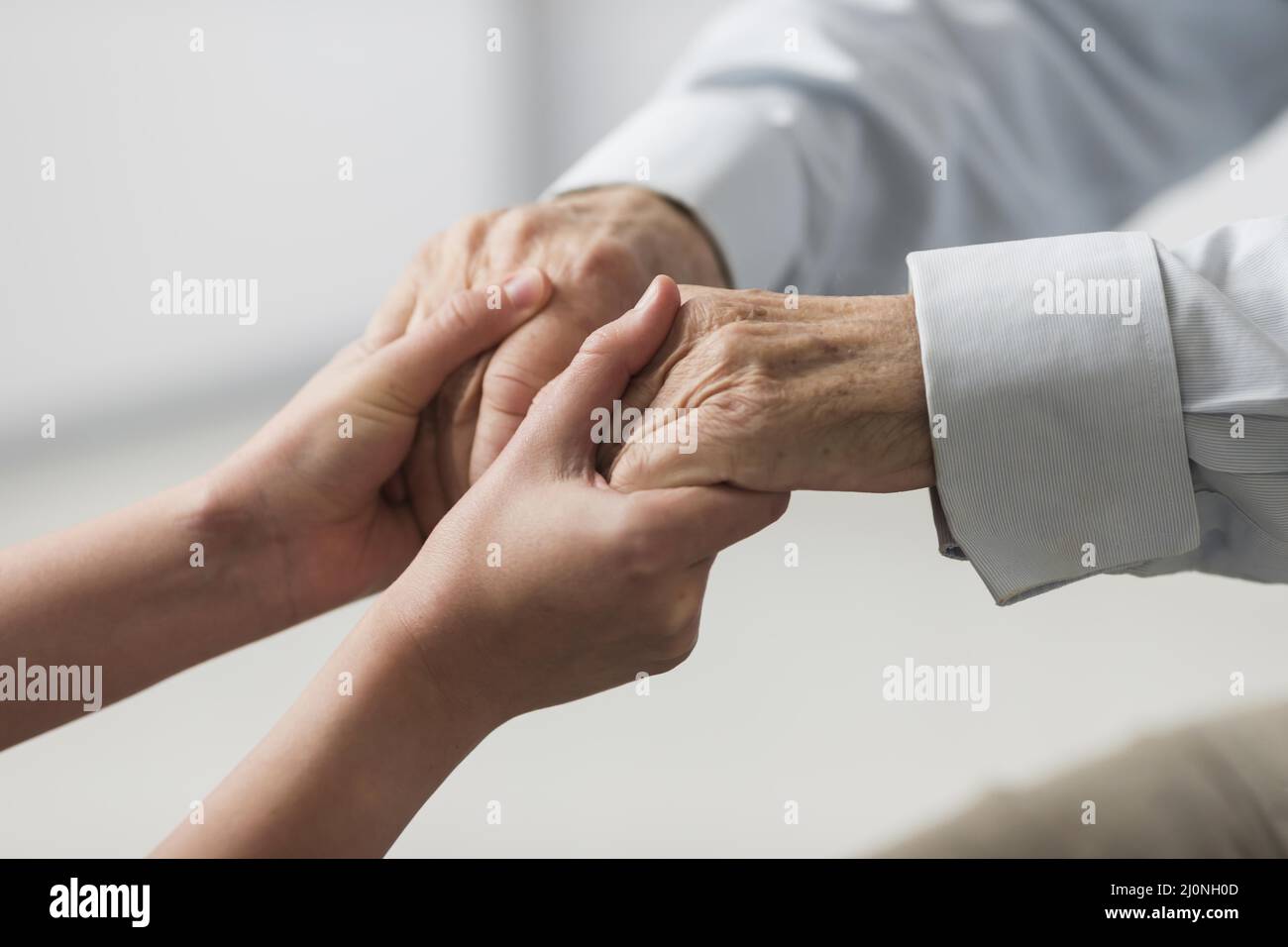 Enfermera sosteniendo la simpatía de las manos del hombre mayor . Alta calidad y resolución Hermoso concepto fotográfico Foto de stock