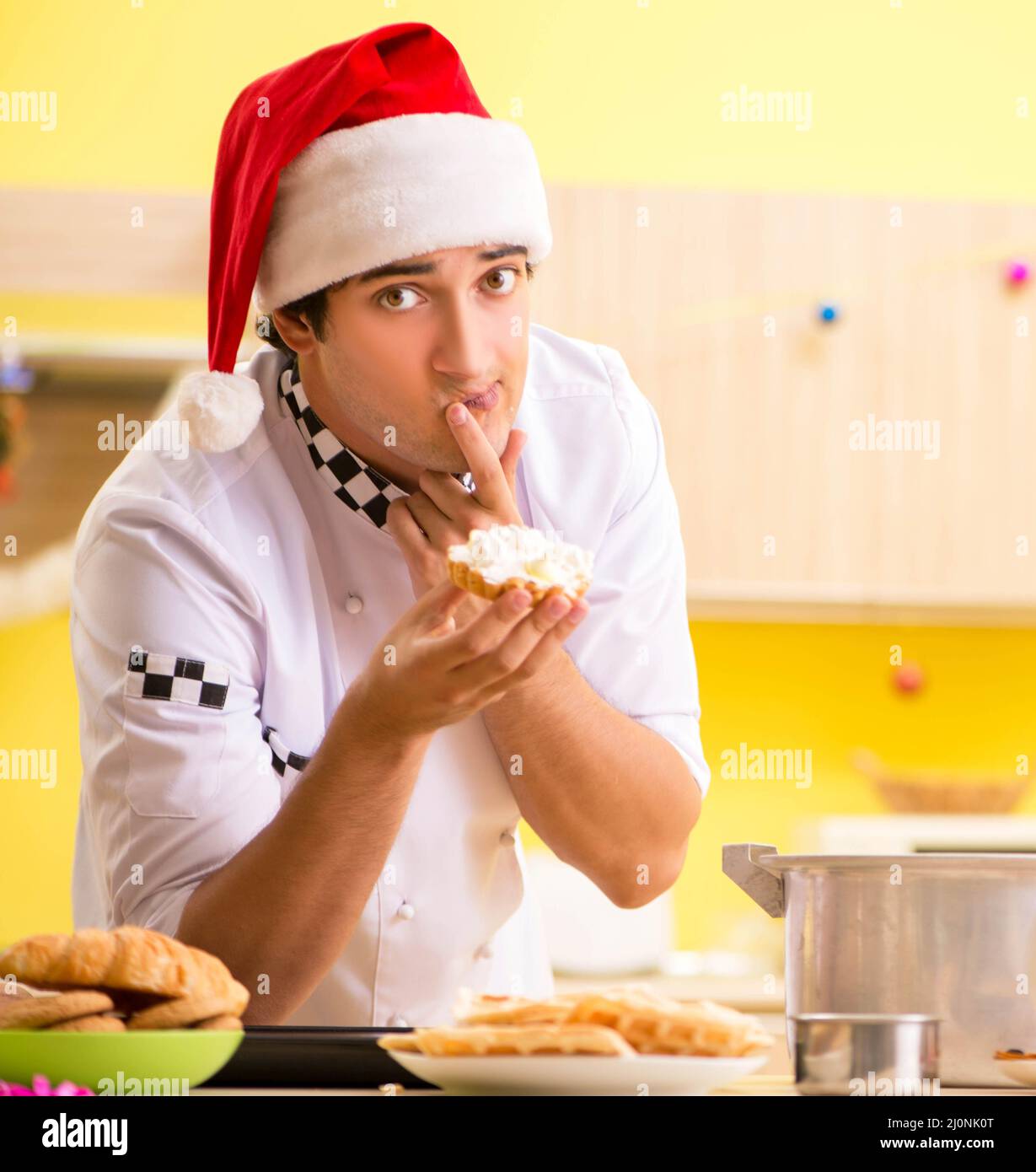 El joven chef marido trabaja en la cocina en la víspera de Navidad Foto de stock