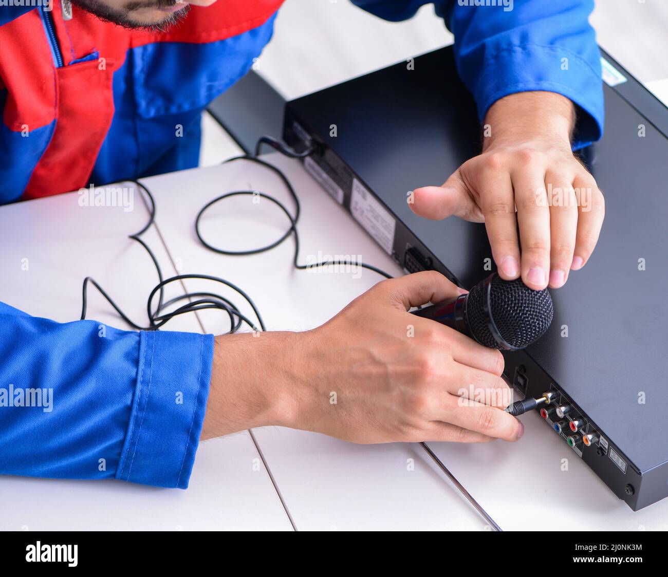 Hombre reparador reparar el reproductor de dvd al centro de servicio Foto de stock