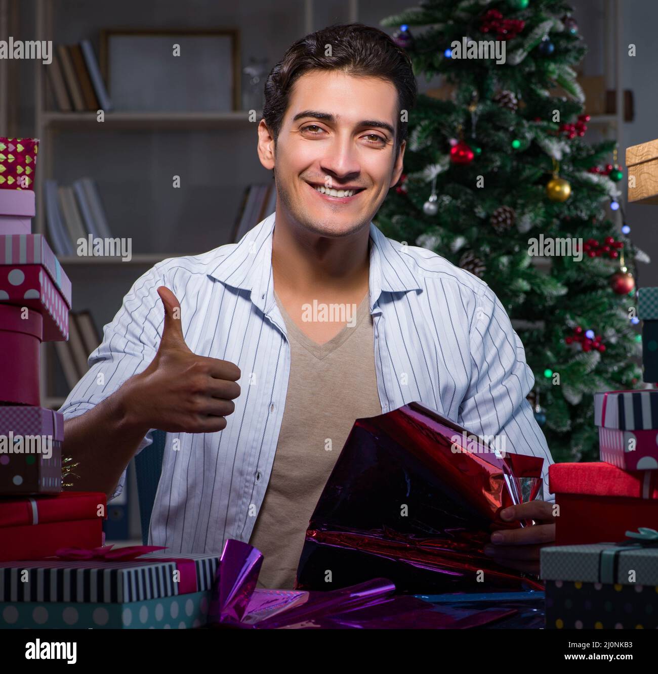 Hombre con muchos regalos de Navidad en cajas Foto de stock